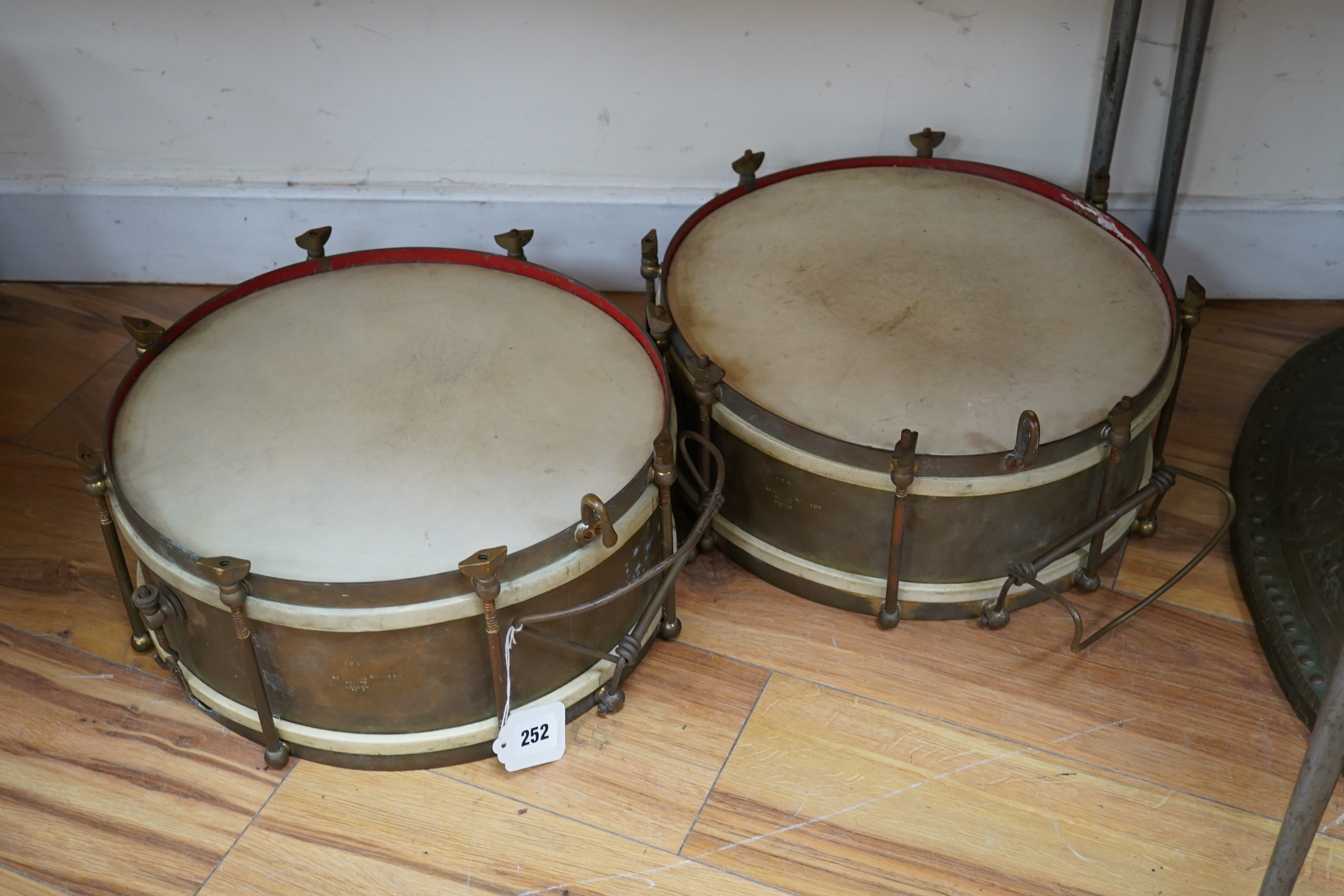 A pair of A H Matthews military brass side drums, both stamped London 1949, 35.5cm diameter skin. Condition - fair.